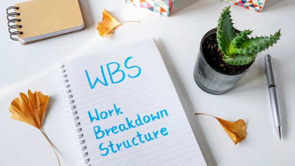 A notebook on a desk that reads WBS Work Breakdown Structure