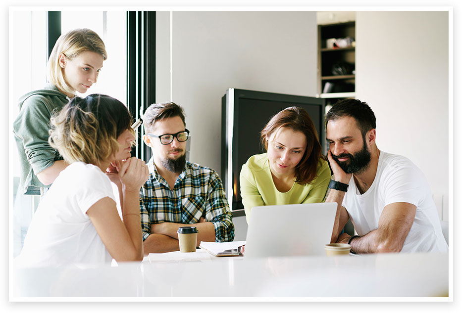 3 women and 2 men sitting around a laptop planning a sprint